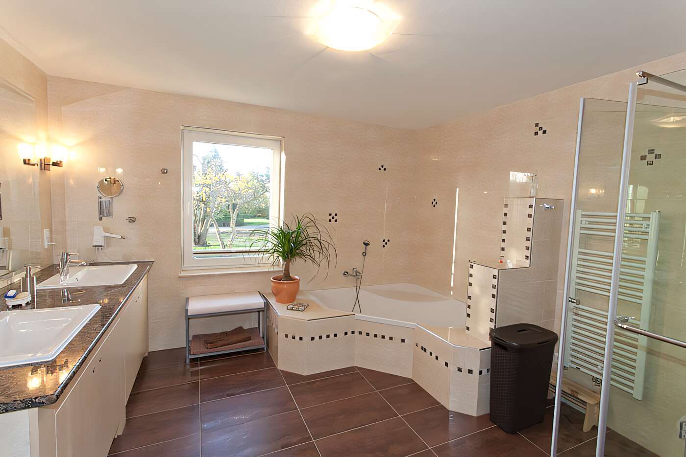 Das groe Bad des Ferienhauses mit Dusche, Eckbadewanne, Waschmaschine und Wschetrockner im Erdgeschoss